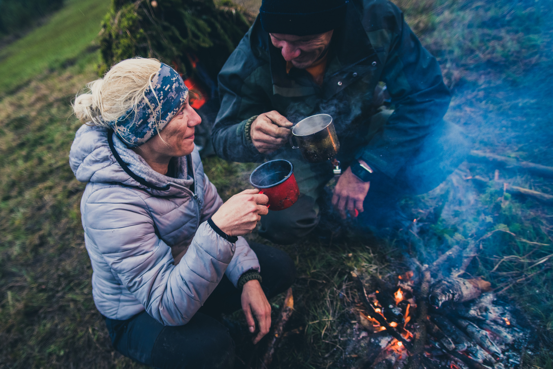 Hiker couple toasting with warm tea in the wilderness